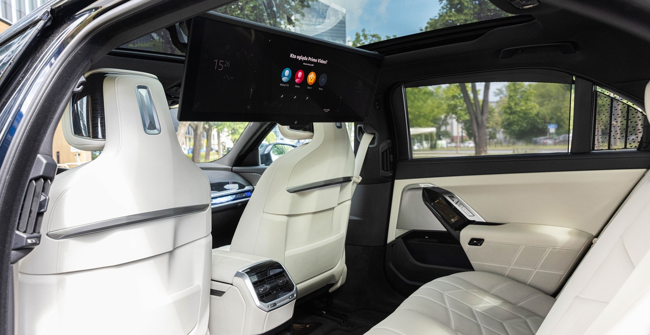 Задний ряд BMW 740d xDrive M Sport с премиальной отделкой, сенсорным управлением и экраном BMW Theatre Screen. Максимальный комфорт и кино в дороге — доступно в SK CARS в Варшаве.