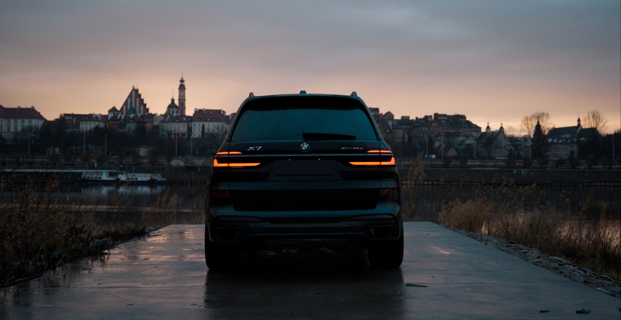 BMW X7 xDrive40d на фоне рассветной Варшавы у Вислы — аренда премиального внедорожника в SK CARS.