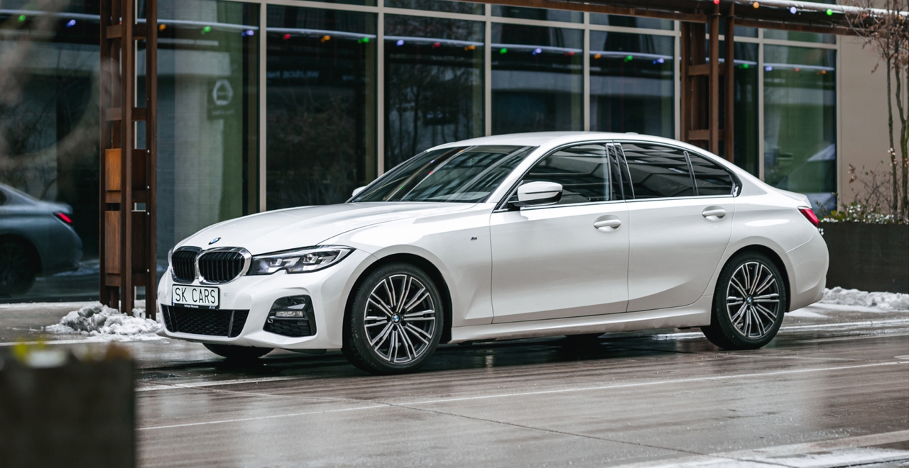 Белый BMW 3 серии перед современным зданием. Элегантный седан в аренду от SK CARS для комфортных поездок в городе и за его пределами.
