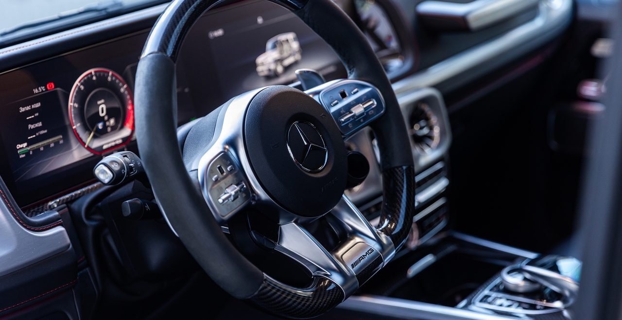 Интерьер Mercedes-AMG G63 с рулём AMG Performance, цифровой приборной панелью и элементами карбона — сочетание мощности и премиального дизайна.