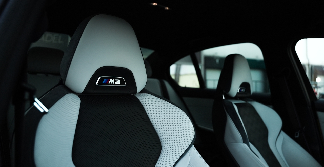 Спортивные передние сиденья BMW M3 Competition с логотипом M3 и комбинированной отделкой.