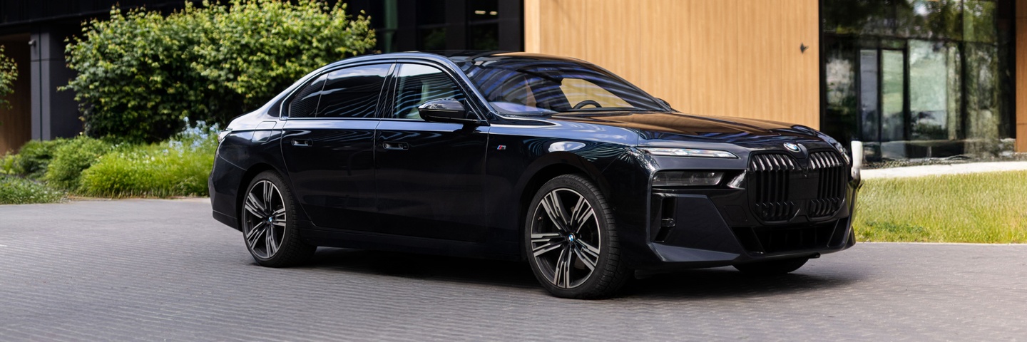 BMW 740d xDrive – next-generation premium sedan with M package, captured in sleek black against Warsaw’s modern cityscape. Rent this car at SK CARS.