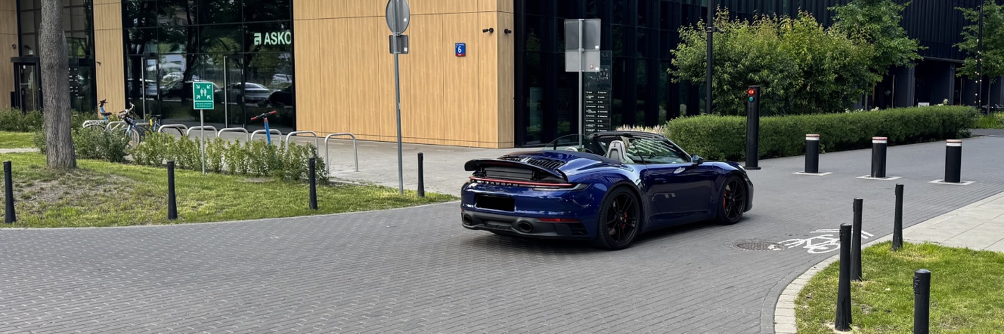 Porsche 911 Carrera 4 GTS Cabriolet в тёмно-синем цвете – вид сзади в движении, аренда Варшава SK CARS
