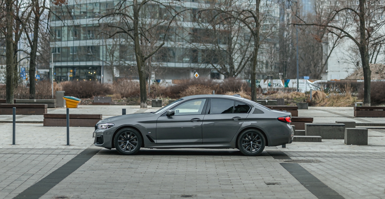 Стильный седан BMW 5 серии на фоне городской архитектуры. Прокат премиальных автомобилей в SK CARS.
