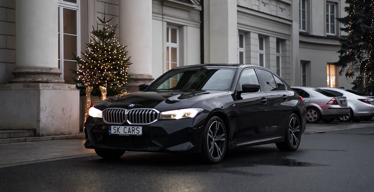 Элегантный BMW Series 3 перед празднично украшенным отелем, подчеркивающий роскошь и комфорт аренды с SK Cars.