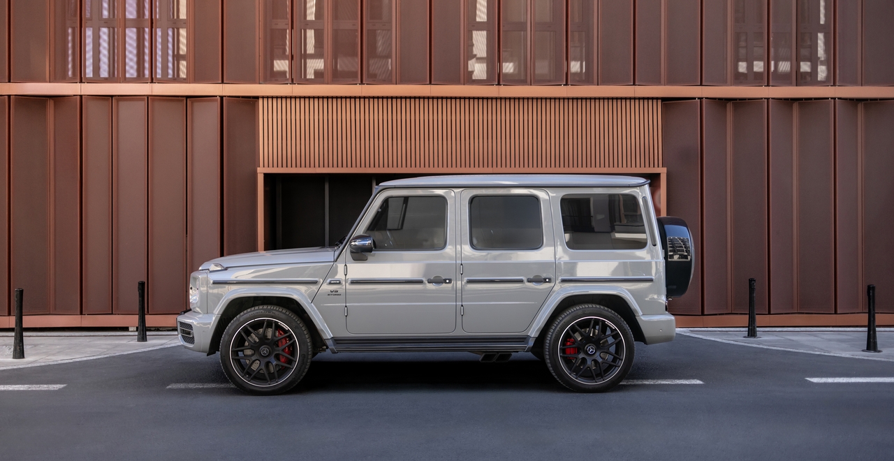 Mercedes-AMG G63 на фоне современного здания: мощный внедорожник с характерным дизайном, выразительными дисками и агрессивным стилем, сочетающий роскошь и проходимость.
