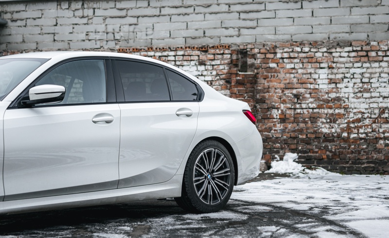 Задняя часть белого BMW 3 серии, подчеркивающая динамичный и элегантный дизайн. Автомобиль доступен для аренды в SK CARS.