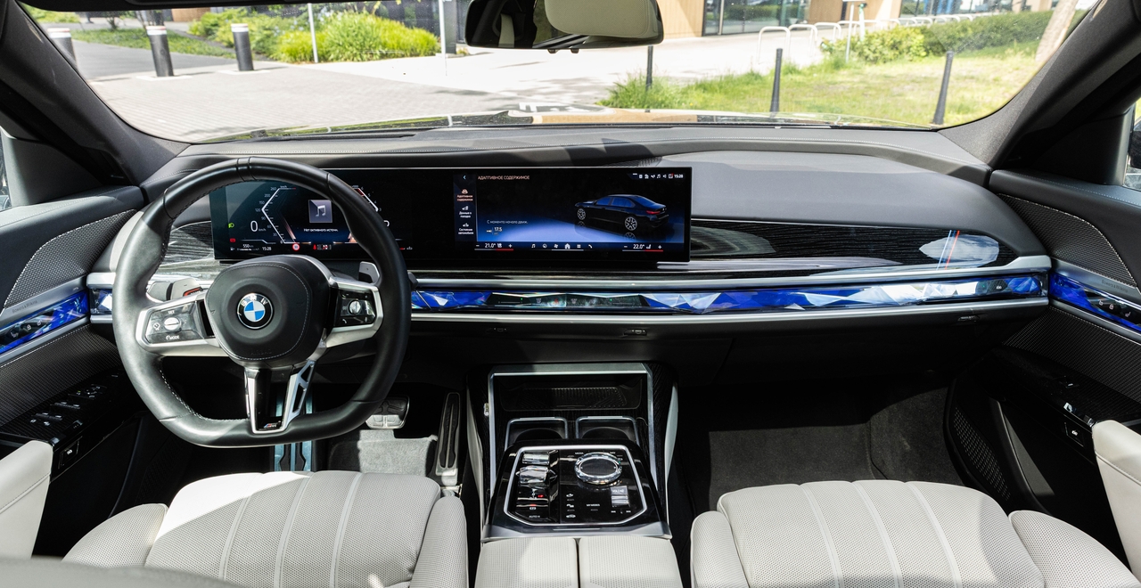 Интерьер BMW 740d xDrive M Sport — цифровая панель, кристаллический селектор КПП, голубая подсветка и премиальные материалы. Аренда доступна в SK CARS в Варшаве.