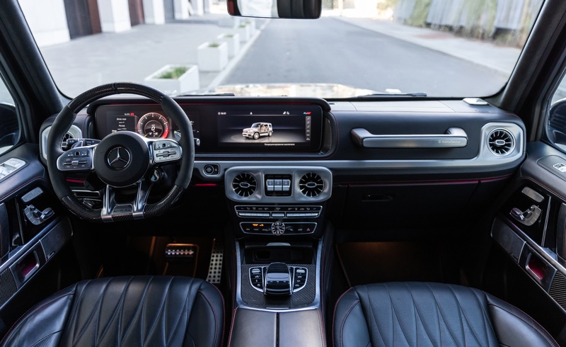 Интерьер Mercedes-AMG G63 с кожаной отделкой, спортивным рулём и цифровой панелью с дисплеем G-Class.